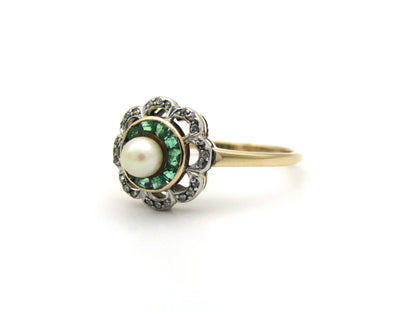 9K gold Edwardian pearl, emerald, and diamond flower ring, circa 1905.