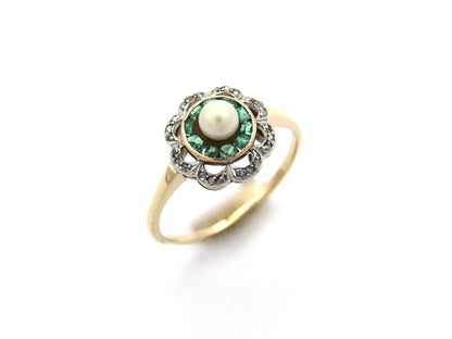 9K gold Edwardian pearl, emerald, and diamond flower ring, circa 1905.
