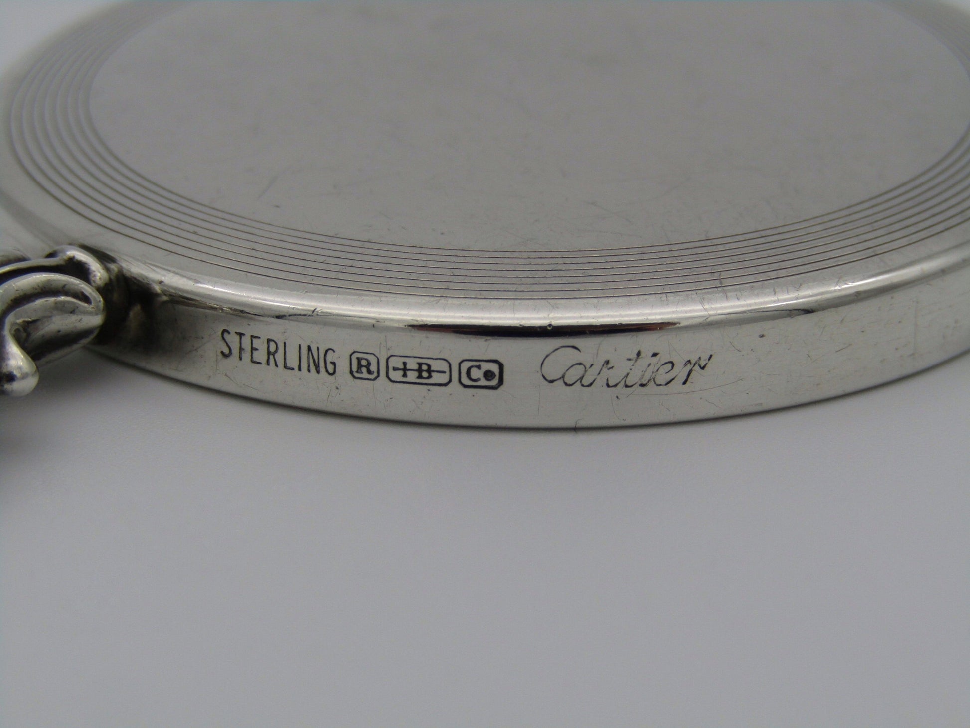 A sterling silver hand mirror by Cartier. Circa 1920s.